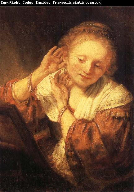 REMBRANDT Harmenszoon van Rijn Young Woman Trying on Earrings